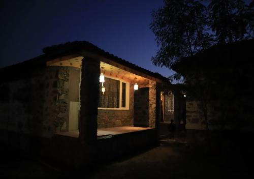 a house lit up at night with a window at Virat Resorts, Sariska Rajasthan in Bairāt
