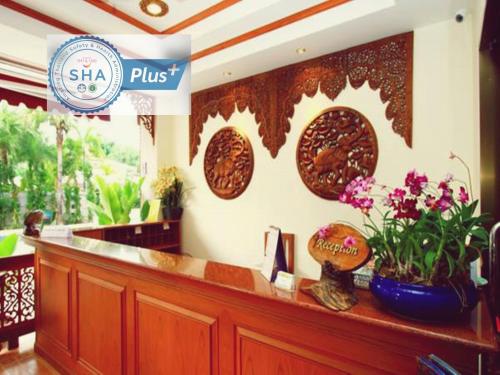 a restaurant with a counter with flowers on it at The Orchid House - SHA Extra Plus in Kata Beach