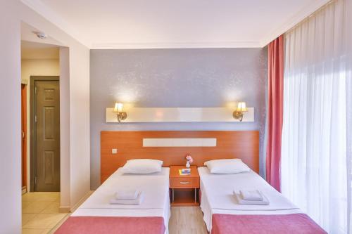 a bedroom with two beds and a window at Kas Bilgin Hotel in Kas