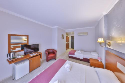 a hotel room with a bed and a television at Kas Bilgin Hotel in Kas