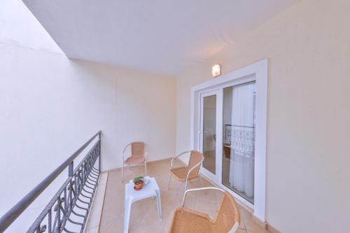 a balcony with chairs and a table and a window at Kas Bilgin Hotel in Kas