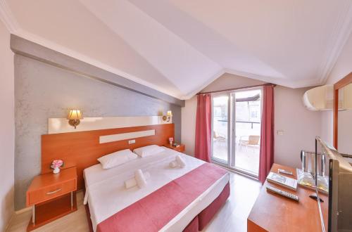 a bedroom with a large bed and a window at Kas Bilgin Hotel in Kas