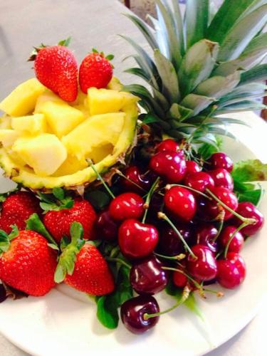 a plate of fruit with a pineapple and strawberries at Hotel Villa Aurora in Lezzeno