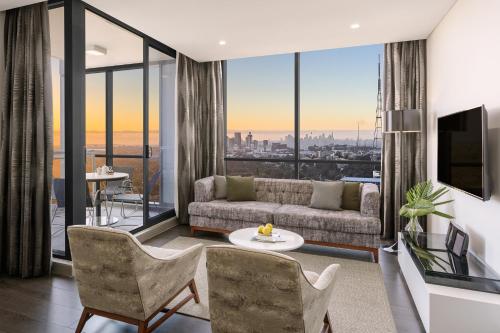 a living room filled with furniture and a large window at Meriton Suites Chatswood in Sydney