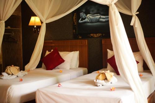 two beds with stuffed animals on them in a room at Kubuku Eco Dive Lodge and Yoga in Pemuteran