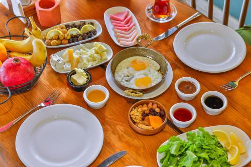 a wooden table topped with plates and bowls of food at Kas Bilgin Hotel in Kas