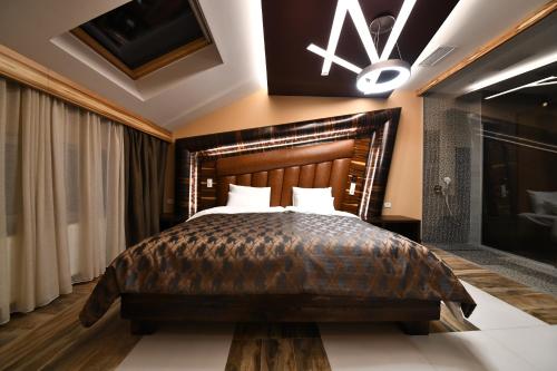 a bedroom with a large bed with a wooden headboard at Hotel Havana Loznica in Loznica
