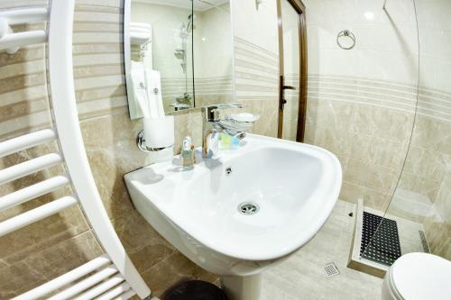 een badkamer met een witte wastafel en een toilet bij Sina Hotel in Tbilisi City
