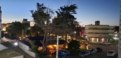 Una ciudad de noche con coches estacionados en un estacionamiento en Villa Gesell Abagú Apartments - Argentina en Villa Gesell
