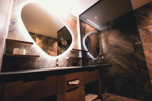 a bathroom with a sink and a mirror at SOULSISTERS' Hotel 4 Sterne Superior in Kaprun