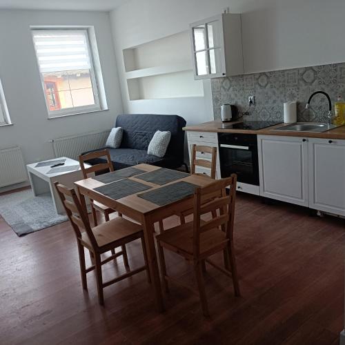 een keuken en eetkamer met een tafel en stoelen bij Apartament Centrum Szczytno III in Szczytno