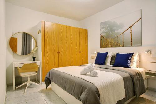 1 dormitorio con cama, escritorio y espejo en Little Gem, en Cruce de Arinaga