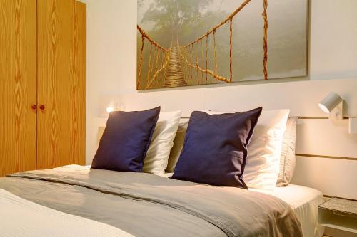 a bedroom with a bed with blue pillows and a bridge at Little Gem in Cruce de Arinaga