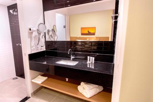a bathroom with a sink and a mirror at Promenade Bonito All Suites in Bonito
