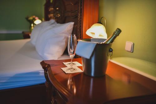 a table with a wine glass and a basket on a bed at Zámek Kamenný Dvůr in Kynšperk nad Ohří