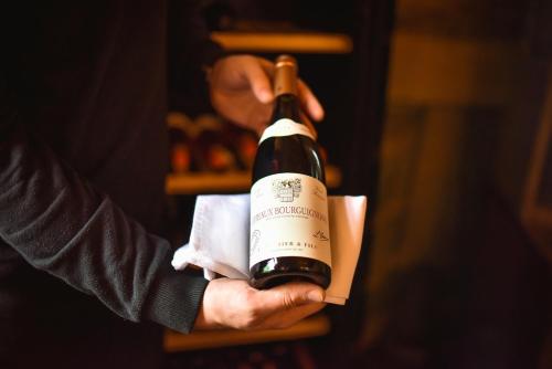 a person is holding a bottle of wine at Zámek Kamenný Dvůr in Kynšperk nad Ohří