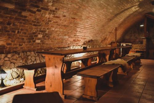 a row of wooden benches in a room with a brick wall at Zámek Kamenný Dvůr in Kynšperk nad Ohří
