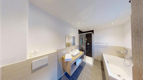 a bathroom with a sink and a toilet and a tub at A CASA Rubin Chalet & Studio Resort in Sölden