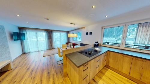 a large kitchen with wooden floors and large windows at A CASA Rubin Chalet & Studio Resort in Sölden