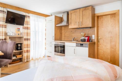 a small kitchen with white cabinets and a sink at Biobauernhof Tonimörtl in Mariapfarr
