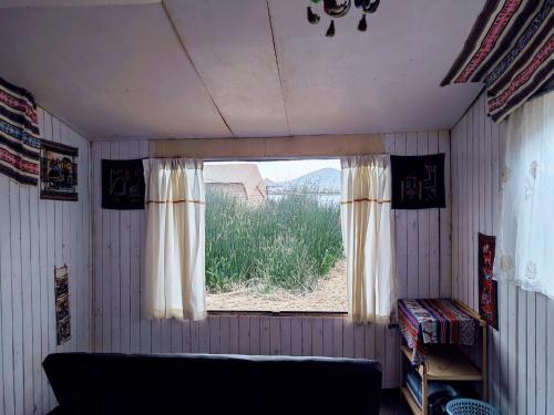 ein Zimmer mit einem Fenster mit einem Sofa darin in der Unterkunft Quechua lodge Titicaca in Puno