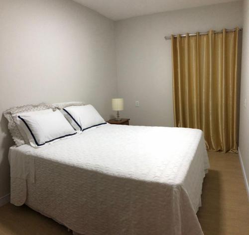 a bedroom with a white bed and a window at Almada Studio 77 in Cunha