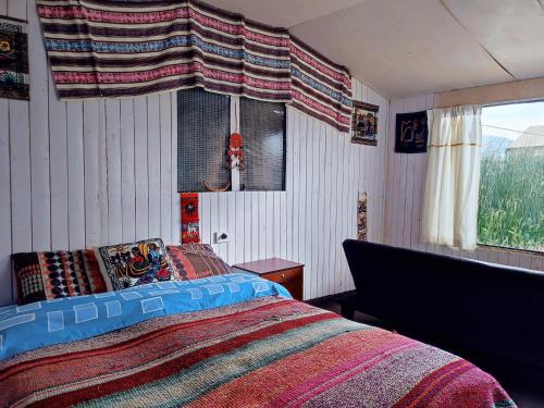 1 dormitorio con cama y ventana en Quechua lodge Titicaca, en Puno