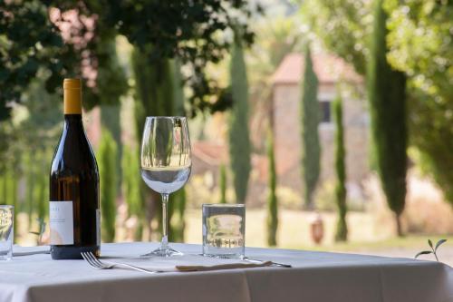 a bottle of wine and a glass on a table at Relais Ciavatta Country Hotel in Montemerano