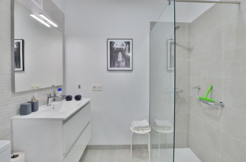 a white bathroom with a shower and a sink at Costa Isora in Puerto de Santiago
