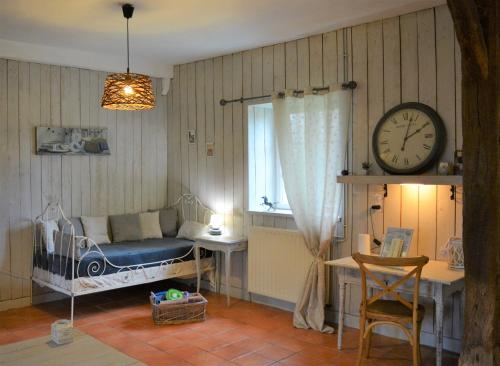 a bedroom with a bed and a clock on the wall at Gite De Saba in La Celle-Condé