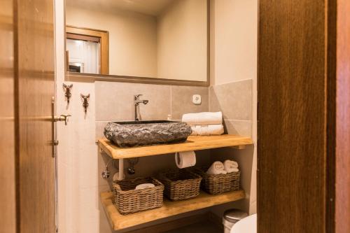 a bathroom with a sink and towels on a shelf at Alpenchalet Reit im Winkl in Reit im Winkl
