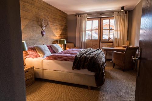 1 dormitorio con cama, escritorio y ventana en Alpenchalet Reit im Winkl, en Reit im Winkl