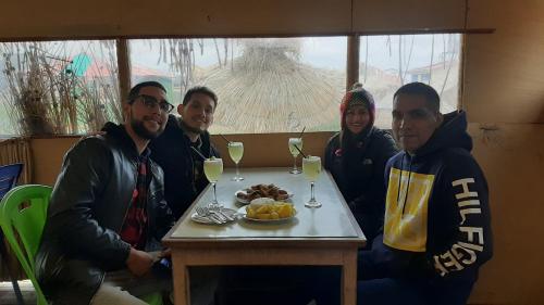 a group of people sitting around a table with wine glasses at Quechua lodge Titicaca in Puno