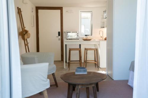 a living room with a table and a kitchen at Casagrande Hotel & Beach Club in José Ignacio