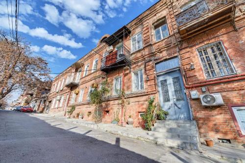 ceglany budynek z niebieskimi drzwiami na ulicy w obiekcie House 52 Boutique Hotel w mieście Tbilisi City