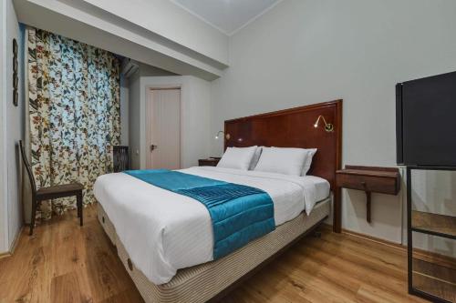 a bedroom with a large bed and a flat screen tv at House 52 Boutique Hotel in Tbilisi City