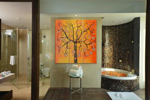 a bathroom with a painting of a tree at Holiday Inn Chandigarh Panchkula, an IHG Hotel in Chandīgarh