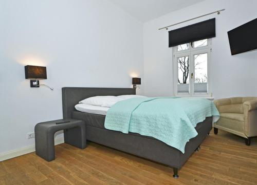 ヘリングスドルフにあるHohe Buchen Apartment 1のベッドルーム1室(ベッド1台、椅子、窓付)