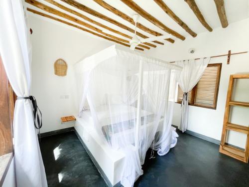 a room with white curtains and a staircase at Nakupenda paje villa in Paje