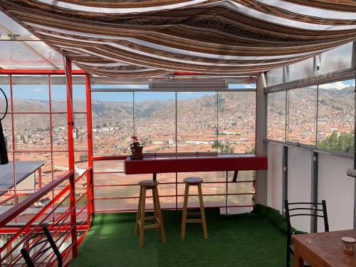 a room with a table and two stools and a view at Summit Viewpoint House San Blas in Cusco