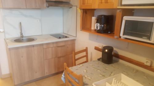 une petite cuisine avec une table et un micro-ondes dans l'établissement Bolquere P2000 by Marie&Rafael, à Bolquère-Pyrénées 2000