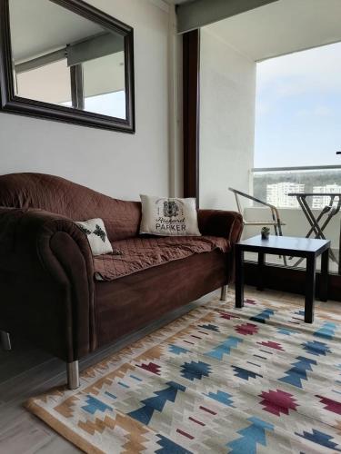 a living room with a brown couch and a table at Eluchans Plaza 2 in Viña del Mar