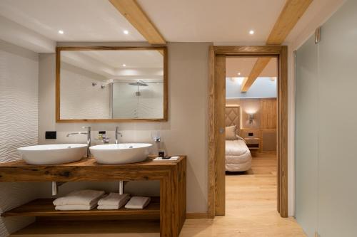 a bathroom with two sinks and a mirror at Hotel Splendid in Madonna di Campiglio
