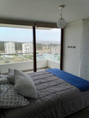 a bedroom with a bed and a large window at Eluchans Plaza 2 in Viña del Mar