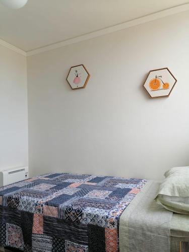 a bedroom with a bed and a clock on the wall at Eluchans Plaza 2 in Viña del Mar