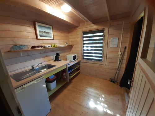 a small kitchen with a sink and a microwave at La Rose du Sud in Saint-Joseph