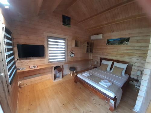 a bedroom with a bed and a flat screen tv at La Rose du Sud in Saint-Joseph