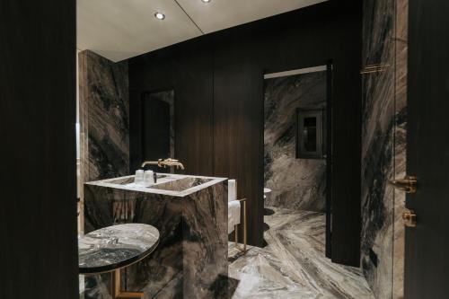 a bathroom with a large marble sink and black walls at Albergo Italia in Matera