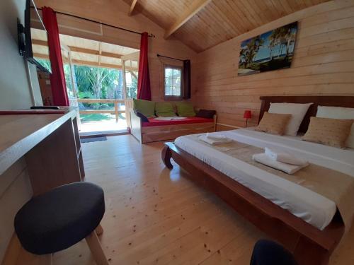 ein Schlafzimmer mit einem großen Bett in einem Holzzimmer in der Unterkunft La Rose du Sud in Saint-Joseph