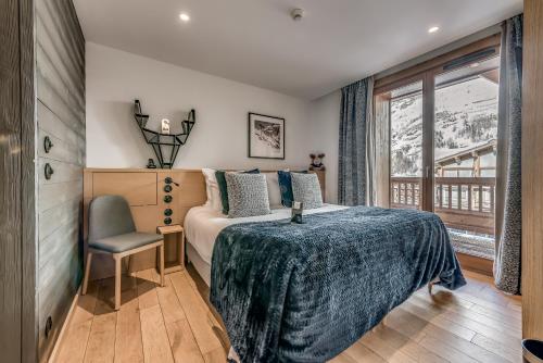 a bedroom with a large bed and a large window at Le Yule Hotel & Spa in Val-d'Isère